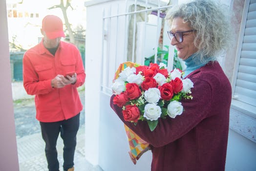A Woman Receiving a Bouquet of Flowers from the Deliveryman